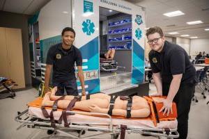 Two EMT students with patient on stretcher